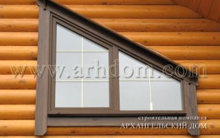 Наружная деревянная отделка трапецевидного окна в бревенчатом доме