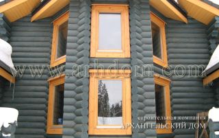 Наружная деревянная отделка окна в эркере дома из бревна